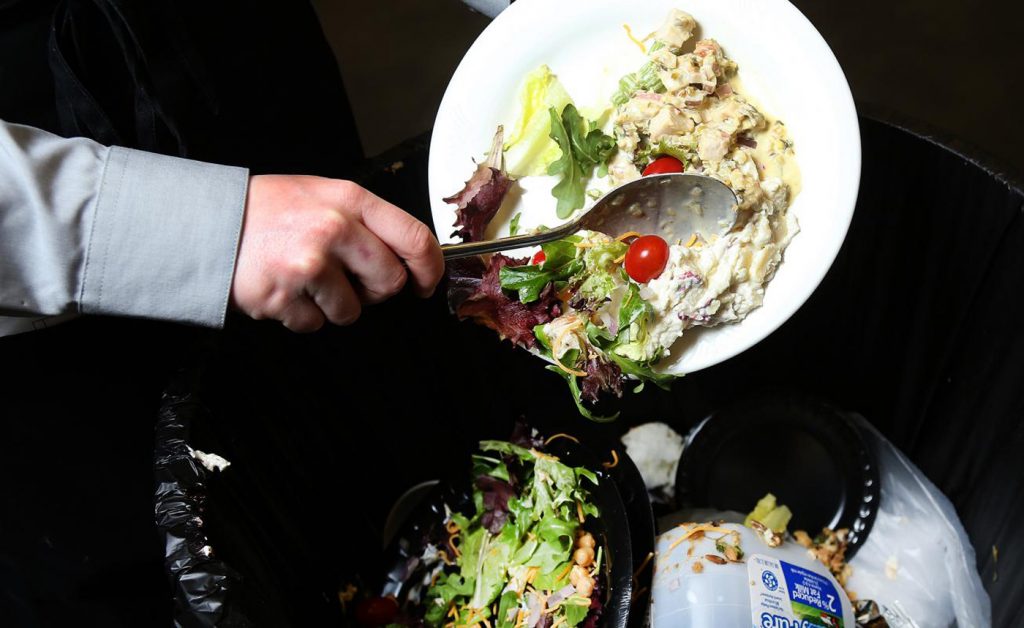 Tirando la comida a la basura en un restaurante.