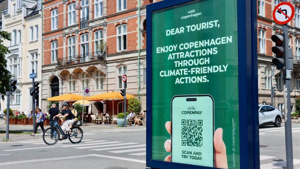 Pubblicità dell'app CopenPay nel centro di Copenaghen per promuovere informazioni sul turismo sostenibile.